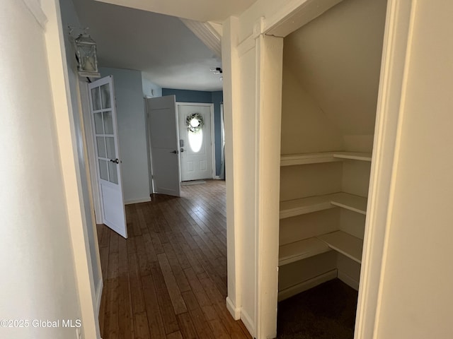 corridor with dark wood finished floors and baseboards