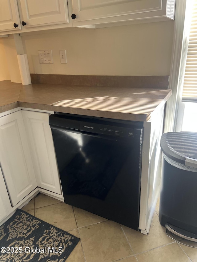 kitchen featuring black dishwasher, white cabinetry, and light tile patterned flooring