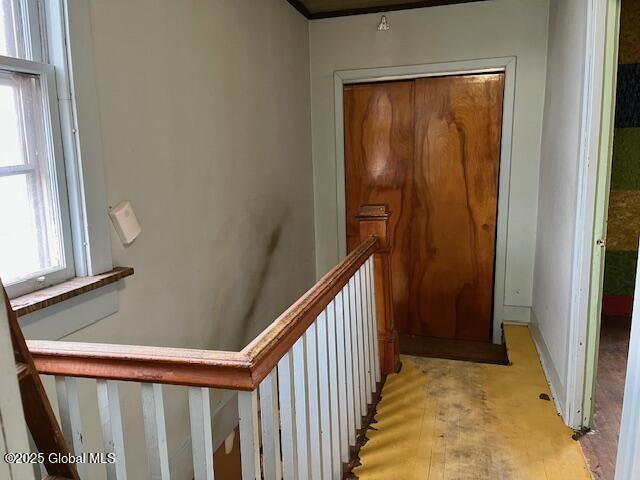 hallway featuring baseboards and an upstairs landing