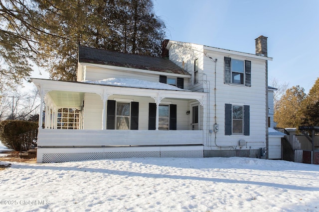 view of front of property featuring a chimney and a porch