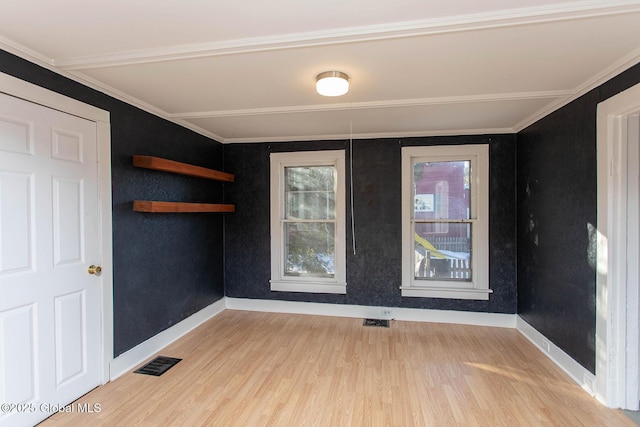 empty room featuring baseboards, visible vents, and wood finished floors