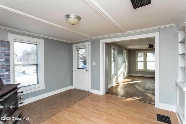 entrance foyer featuring visible vents, crown molding, baseboards, and wood finished floors