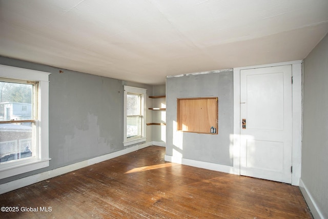 spare room with hardwood / wood-style flooring and baseboards