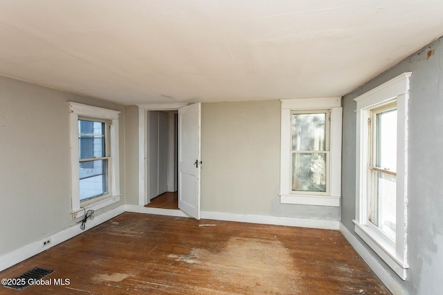 unfurnished room with wood-type flooring and baseboards