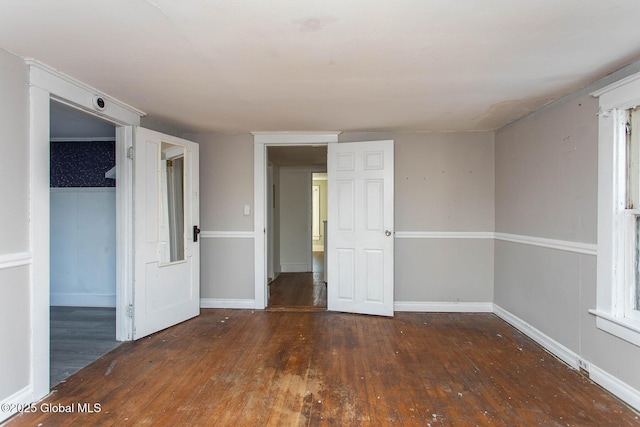 empty room featuring baseboards and hardwood / wood-style flooring