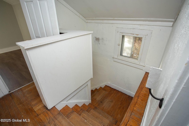 stairway with baseboards, vaulted ceiling, and hardwood / wood-style floors