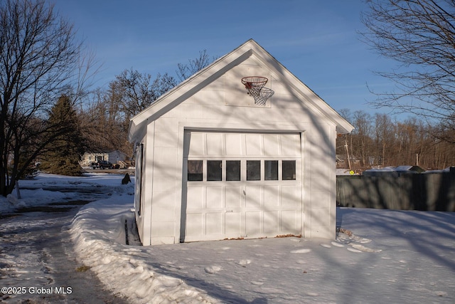 snow covered garage with a detached garage