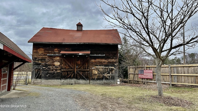 view of barn featuring fence