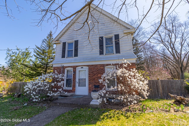 view of front of house with fence and brick siding