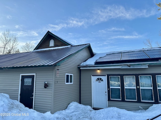 view of front facade with metal roof and solar panels