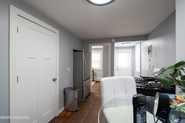 bedroom with freestanding refrigerator and dark wood finished floors