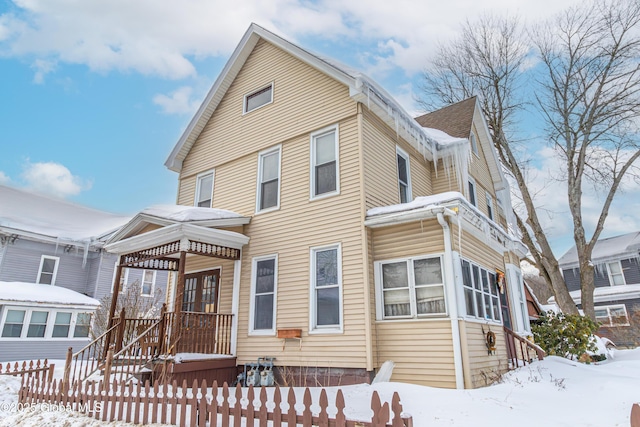 view of front of home featuring a shingled roof and fence