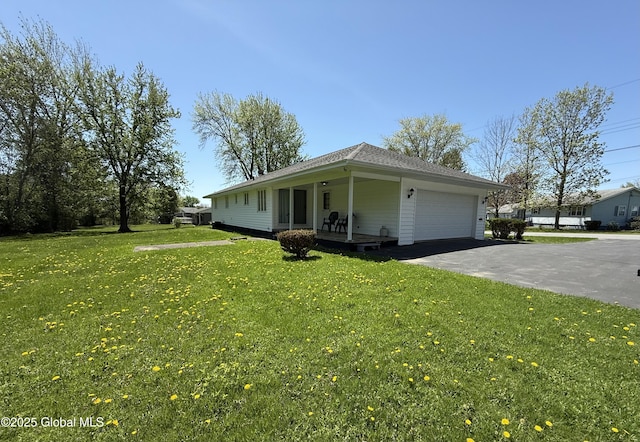24 Regina Ln, Amsterdam, NY 12010 - single story home featuring covered porch, a front yard, an attached garage, and driveway
