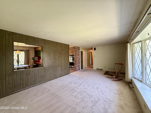 24 Regina Ln, Amsterdam, NY 12010 - unfurnished living room featuring wood walls, carpet flooring, and a fireplace