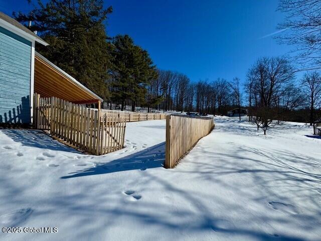 yard layered in snow with fence