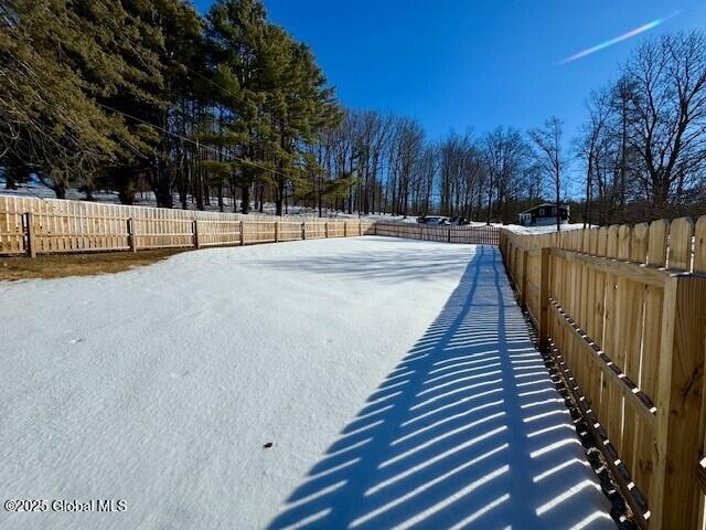 yard covered in snow with fence