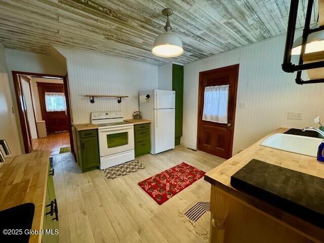 kitchen with white appliances, a sink, light wood-type flooring, green cabinets, and wooden counters