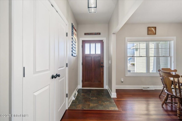 foyer entrance featuring a wealth of natural light, baseboards, visible vents, and wood finished floors