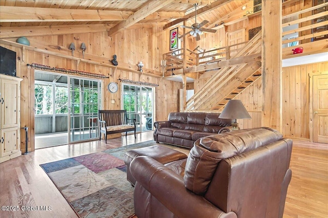 living area featuring beamed ceiling, wood finished floors, wooden walls, and wooden ceiling