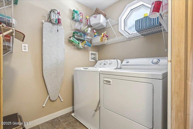 clothes washing area with washer and dryer, baseboards, laundry area, and tile patterned floors