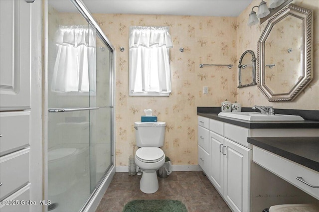 full bath featuring a shower stall, wallpapered walls, vanity, and toilet