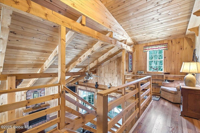 interior space featuring wooden walls, wooden ceiling, lofted ceiling with beams, and wood finished floors