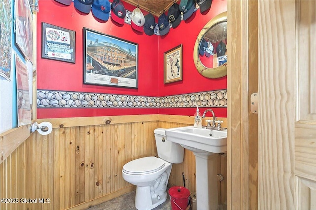 bathroom with a wainscoted wall and toilet