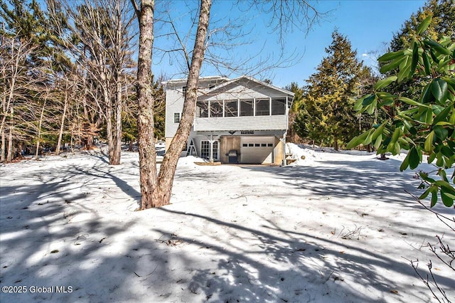 view of front of property featuring an attached garage and a sunroom