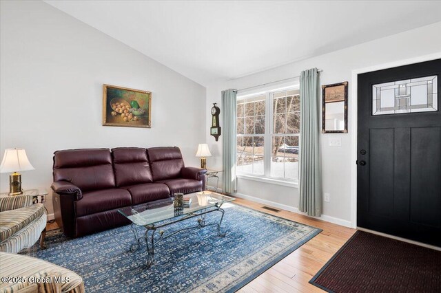 13 Alexander Way, Hudson Falls, NY 12839 - living area featuring visible vents, vaulted ceiling, baseboards, and wood finished floors