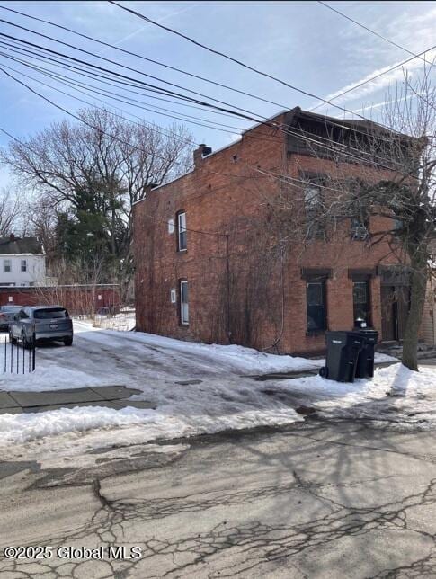 view of snowy exterior with a chimney