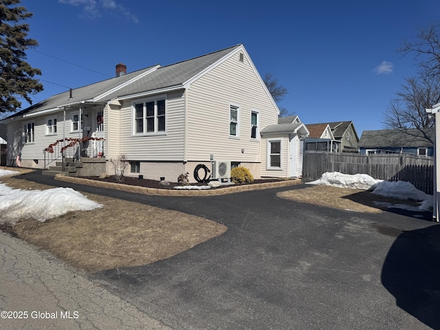 view of side of property with ac unit, a chimney, and fence