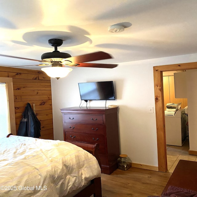 bedroom with a ceiling fan, washer / dryer, and light wood-style floors