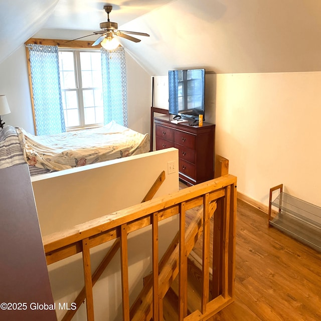 bedroom with vaulted ceiling, ceiling fan, wood finished floors, and baseboards