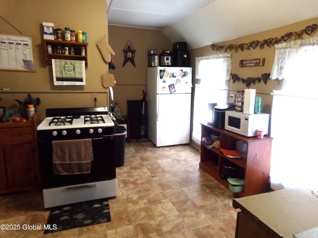 kitchen featuring white appliances and lofted ceiling