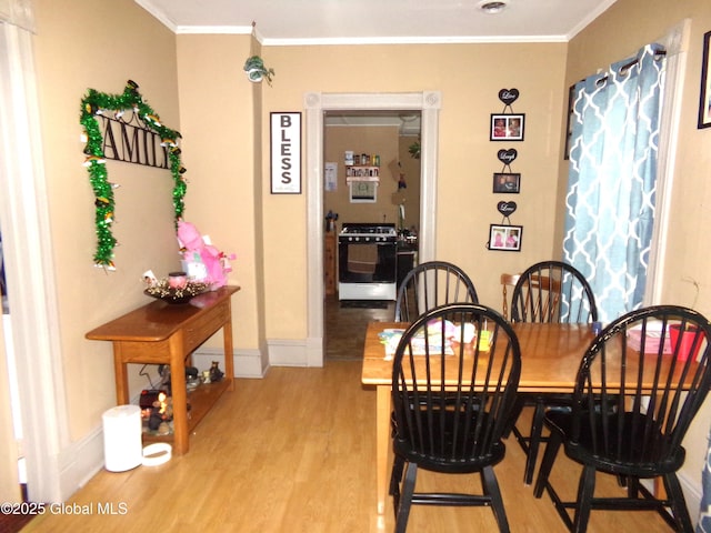 dining area with baseboards, ornamental molding, and light wood finished floors