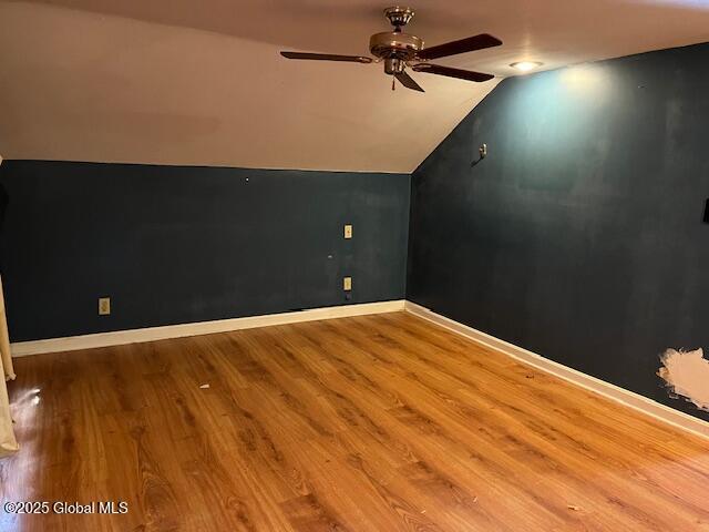 bonus room featuring a ceiling fan, lofted ceiling, baseboards, and wood finished floors