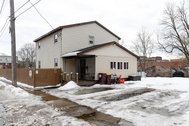 view of front of property with a porch and fence