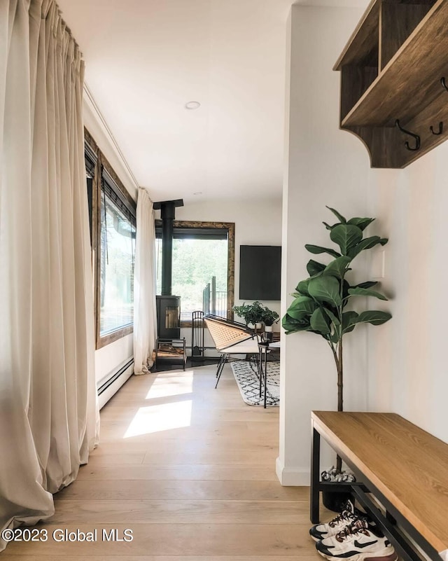 hallway with a baseboard heating unit and light wood-style floors