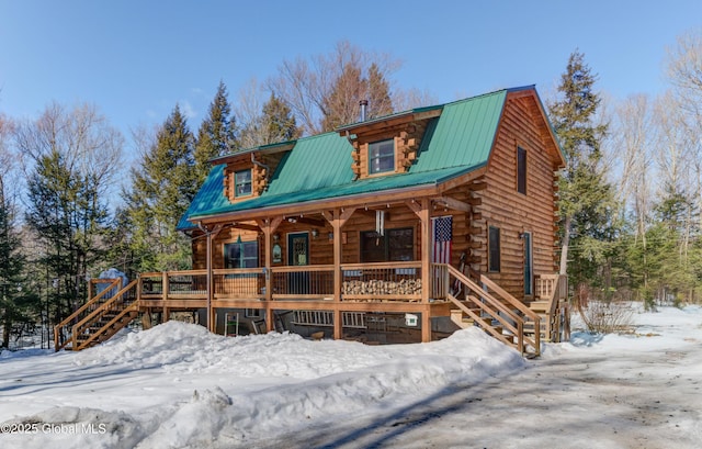 view of front of property with a porch, a gambrel roof, metal roof, log siding, and stairs