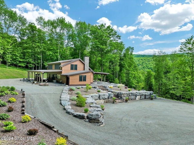 view of community with driveway and a view of trees