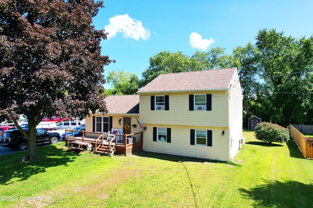 view of front of house featuring a front yard, fence, and a wooden deck