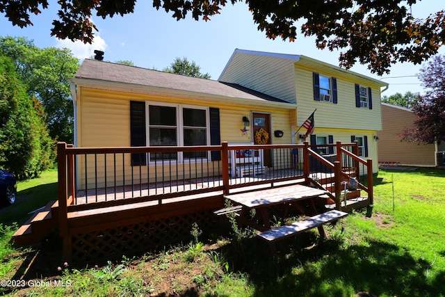 back of property featuring a lawn and a deck