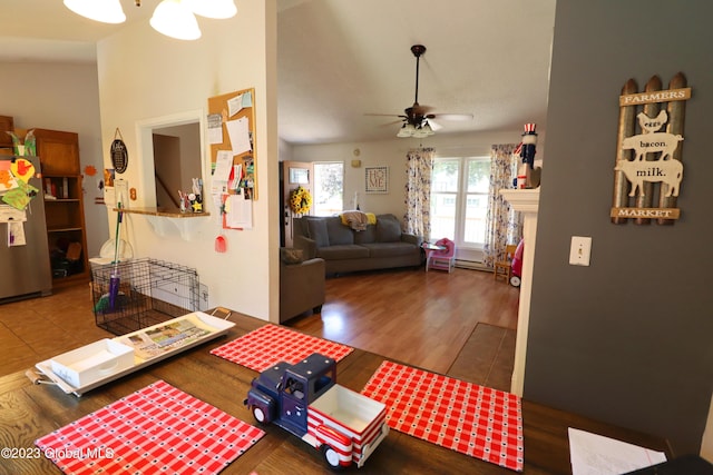 living room featuring ceiling fan, a fireplace, and wood finished floors