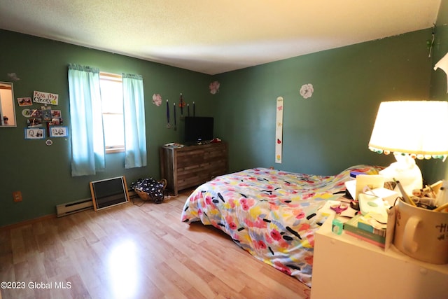 bedroom with a textured ceiling and wood finished floors