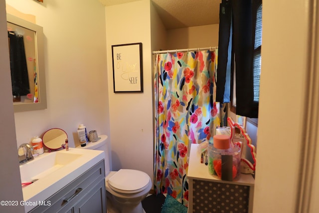 bathroom with toilet, curtained shower, and vanity