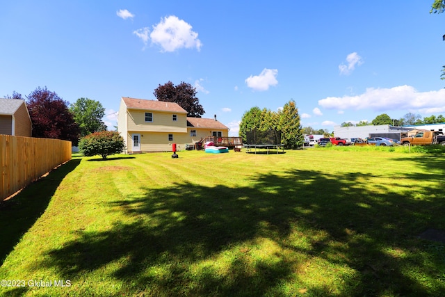 view of yard featuring a trampoline and fence