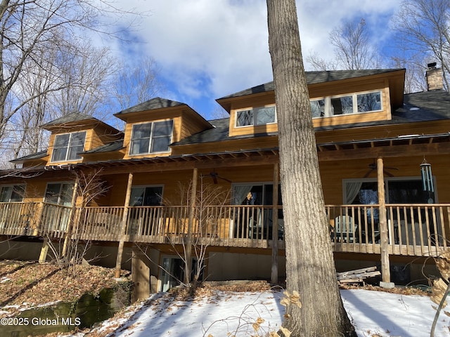 back of house featuring ceiling fan and a chimney