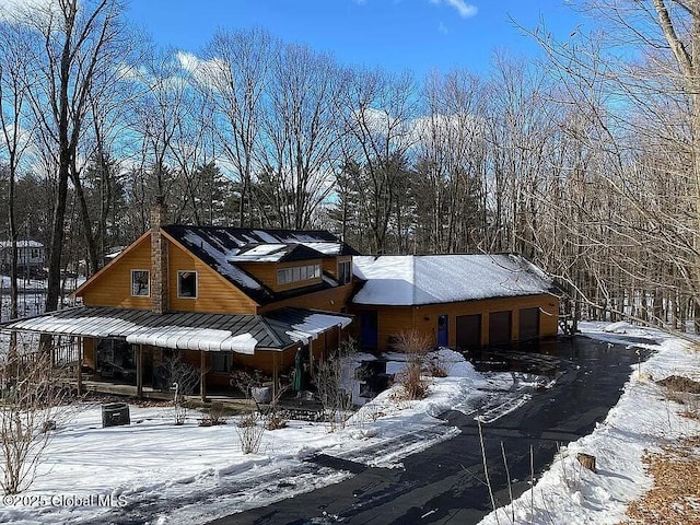 view of front facade with metal roof, driveway, a standing seam roof, and an attached garage