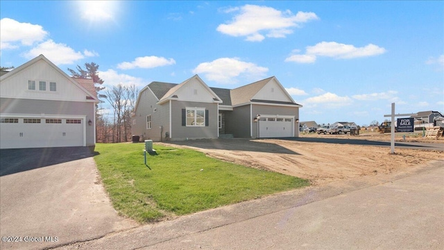 view of front of property with a garage, aphalt driveway, and a front yard