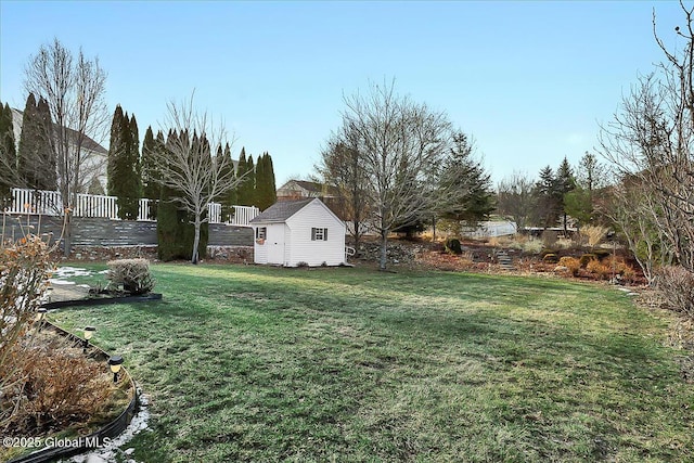 view of yard with an outbuilding, a shed, and fence